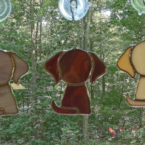 Stained glass Puppies hanging in a window.